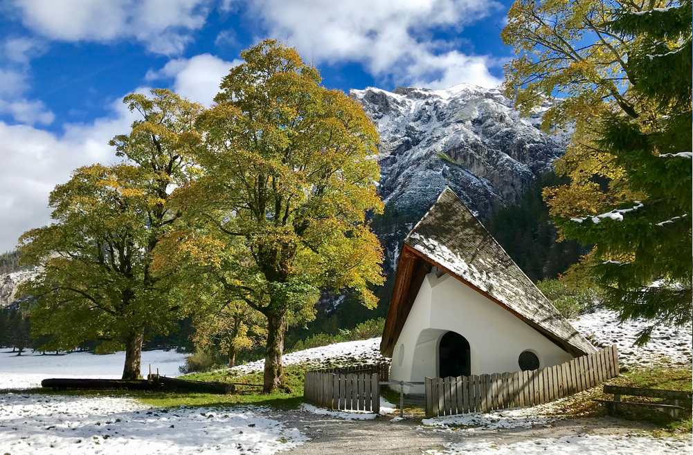 In den Bergen liegt der Schnee, die Bäume leuchten goldgelb im Karwendel