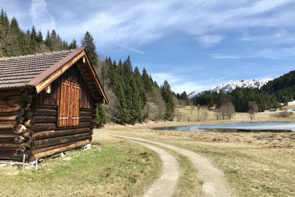 Über diesen breiten Feldweg wandere ich am Geroldsee entlang, vorbei an den Holzstadeln