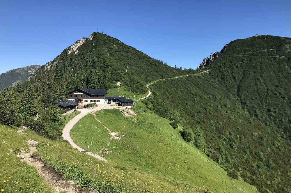 Blick vom Fahrenberg auf Herzogstandhaus und den Martinskopf. Rechts das Pavillon am Herzogstand.