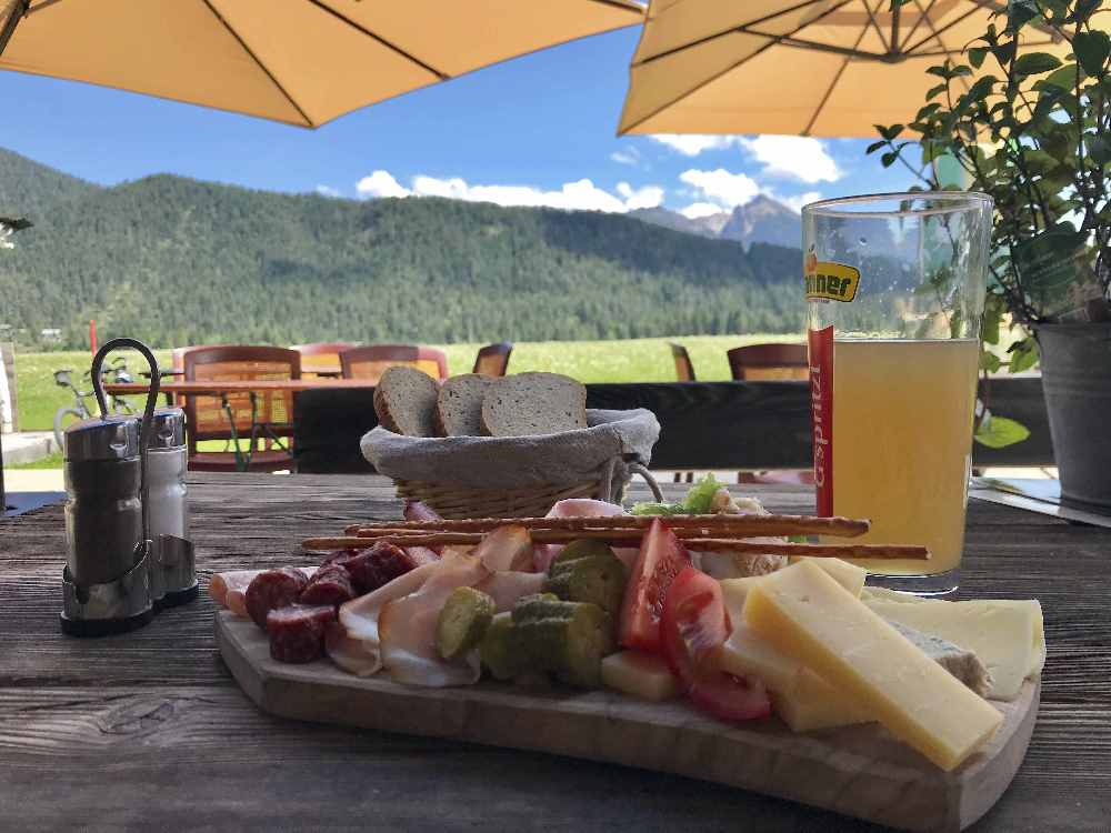 Brotzeit im Tal mit Bergblick auf der Sonnenterrasse bei Poli´s Hütte