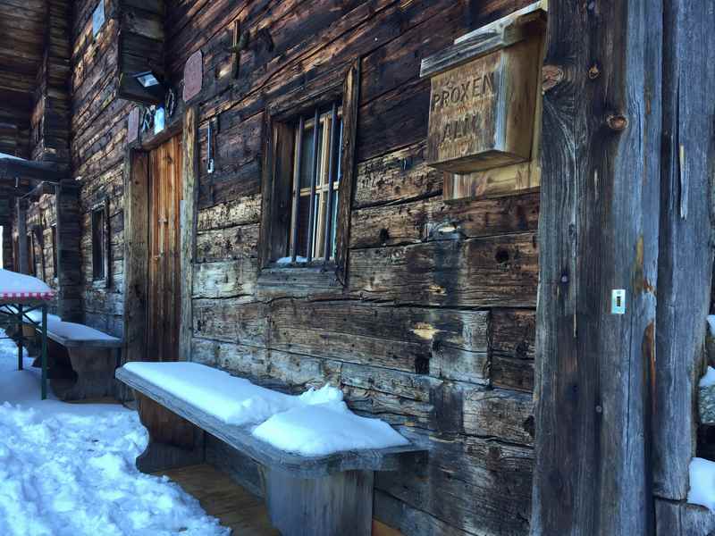 Die alte Holzfassade der Proxenalm - kurzer Stopp bei der Schneeschuhwanderung. Im Hochwinter kommt die Sonne nicht zur Alm