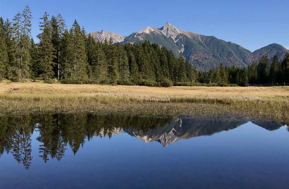 Im kleinen Bergsee in Wildmoos spiegelt sich das Karwendel mit der Reither Spitze