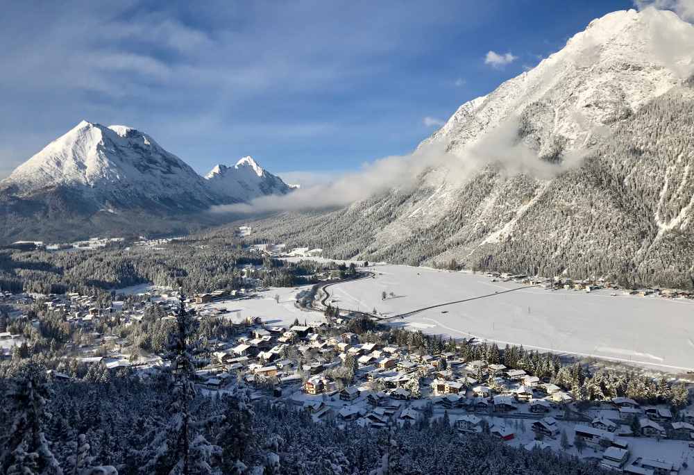 Von der Aussichtsplattform am Kurblhang überblickst du bei der Schneewanderung die Leutasch in Tirol 