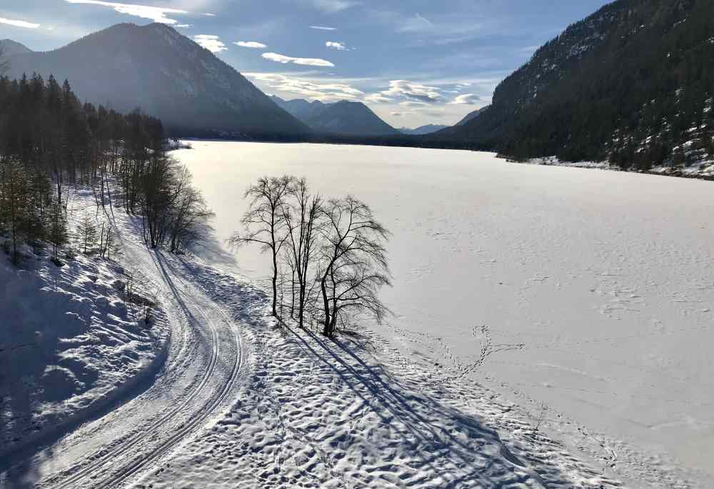 Am zugefrorenen Sylvensteinsee führt links die Langlaufloipe von Fall nach Vorderriß