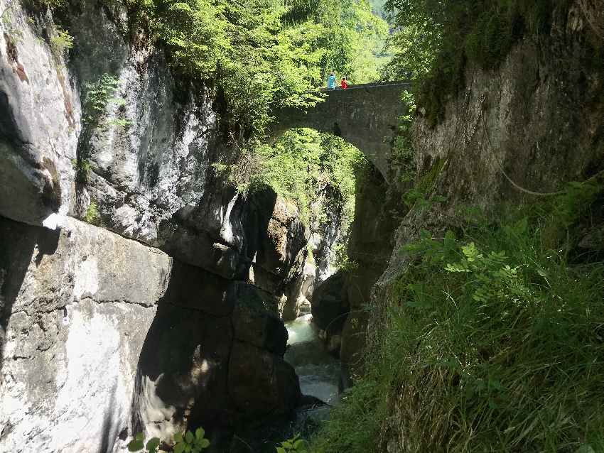 Der Obere Tatzelwurm Wasserfall mit der Steinbrücke - schau die Dimension zwischen den Menschen auf der Brücke und der Tatzelwurm Schlucht!