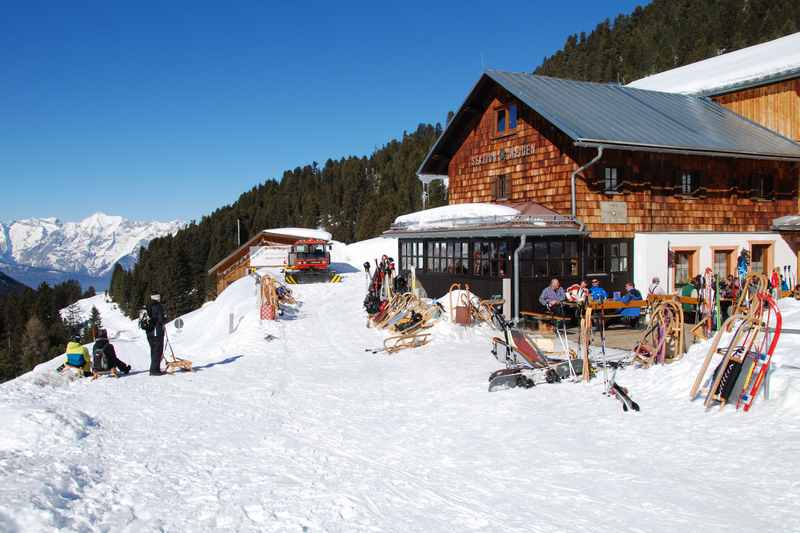 Weidener Hütte rodeln - so geht es auf der sonnigen Terasse zu: Viele Rodler treffen sich hier in den Tuxer Alpen