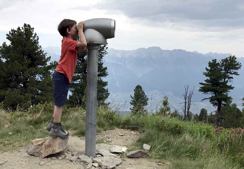 Auf dem Zirbenweg Innsbruck sind auch große "Ferngläser" aufgestellt - die Kinder freuen sich darüber