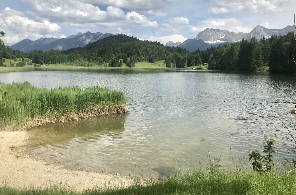 Glasklar ist das Wasser im Geroldsee und weißblau der Himmel mit dem Karwendel